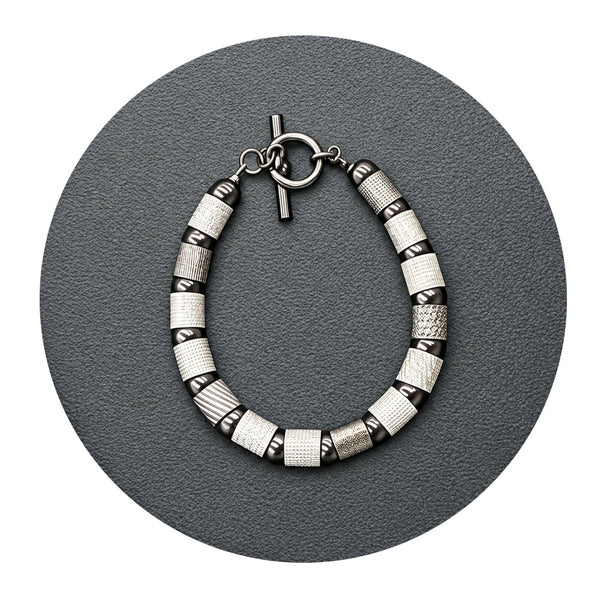 Textured tubes and balls bracelet in silver, rhodium, and black