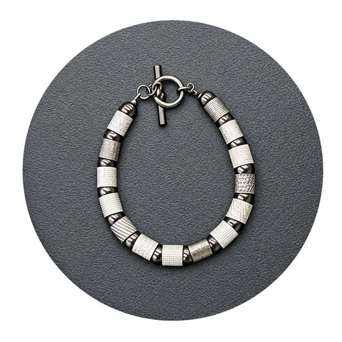 Textured tubes and balls bracelet in silver, rhodium, and black