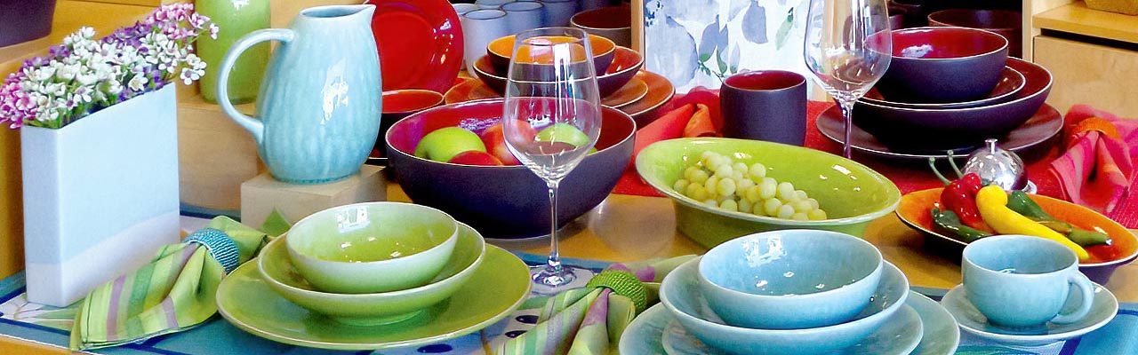A tabletop arrangement of colorful stoneware from Jars Ceramics of Provence, France.